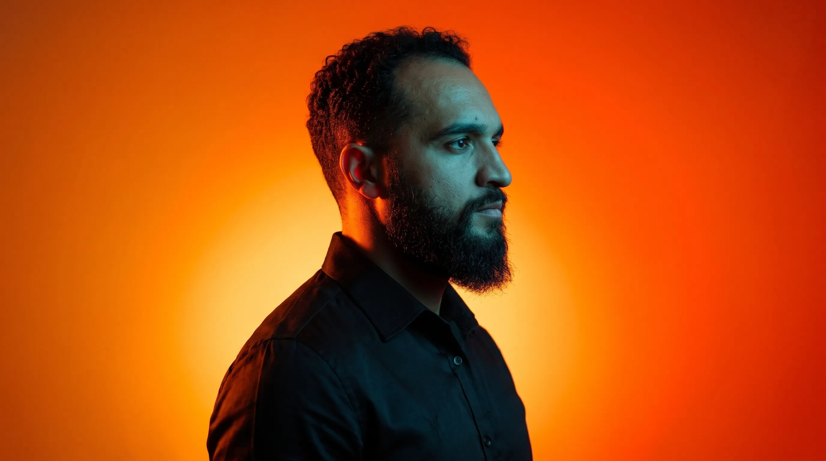 Joanderson, da Kivra Labs, de perfil diante de um fundo laranja